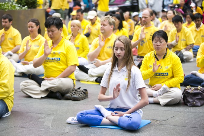 Příznivci metody pro rozvoj těla a mysli zvané Falun Dafa (Falun Gong) předvádějí cvičení během oslav světového dne Falun Dafa, Times Square, New York, 13. května 2015. (Samira Bouaou / Epoch Times)